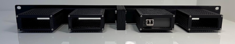 May include: A black rack-mounted server unit with four rectangular compartments. The compartments have a mesh-like design and are mounted on a horizontal metal frame. One compartment has an Ethernet port.