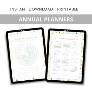 May include: Two digital tablets displaying printable annual planners. One shows a health and well-being goal tracker for 2026, the other a 2026 calendar. The text "INSTANT DOWNLOAD | PRINTABLE" and "ANNUAL PLANNERS" are at the top.