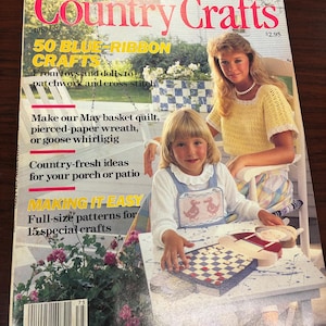 May include: A vintage magazine cover for "Country Crafts" features the title in red script. The cover includes text about crafts, a woman and child, and a checkerboard. The magazine is from 1987 and has a price tag of $2.95.