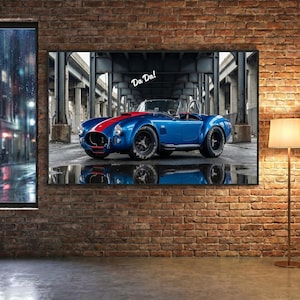 May include: A vibrant blue classic sports car with a red racing stripe, parked under a bridge. The car has black wheels and the text "Da Da!" is above it. The car's reflection is visible in the wet pavement.