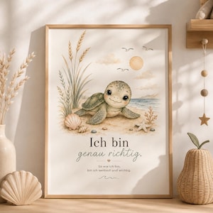 May include: A framed wall art print featuring a cartoon sea turtle on a sandy beach with seashells, tall grass, and a sun in the sky. The text reads: Ich bin genau richtig. So wie ich bin, bin ich wertvoll und wichtig. The print has a light color palette.