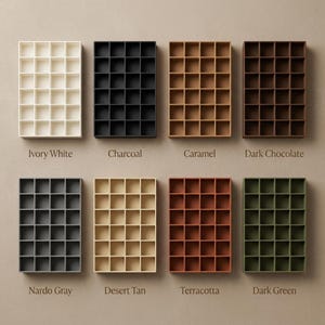 May include: Eight rectangular grid organizers with twenty-four square compartments each, displayed in colors: Ivory White, Charcoal, Caramel, Dark Chocolate, Nardo Gray, Desert Tan, Terracotta, and Dark Green, with labels below each organizer.