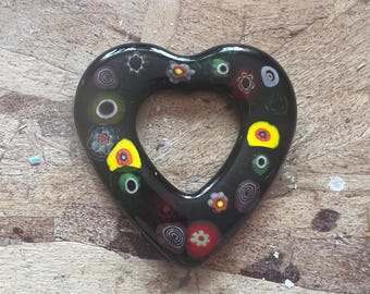 Zwart hart van gesmolten glas met kleurrijke bloemdetails.
