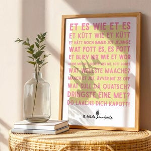 Könnte beinhalten: Ein gerahmter Kunstdruck mit rosa Text in lokalem Dialekt auf einem gelben rechteckigen Hintergrund. Der Text lautet: Et es wie et es, Et kütt wie et kütt, Et hätt noch immer jot jejange, Wat fott es, es fott, Et bliev nix wie et wor, Kenne mer nit, bruche mer nit, fott domet, Wat wellste maache?, Maach et jot, ävver nit ze off, Wat sull dä quatsch?, Dringste eine met?, Do laachs dich kapott!, Et kölsche Jrundjesetz.