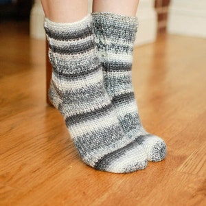May include: A pair of gray and white striped socks with a crocheted texture.