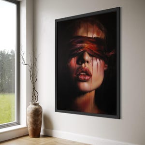 May include: A framed artwork depicting a woman's face with a red blindfold and dripping red paint. The woman's lips are a vibrant red with a glittery texture. The background is dark.
