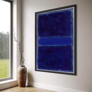 Puede incluir: Una gran pieza de arte mural enmarcada de forma rectangular que presenta una composición abstracta de bloques de color horizontales en azul marino y azul real. La obra está en un marco negro fino y muestra una aplicación de pintura texturizada.