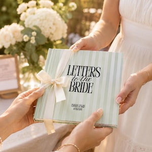 Pode incluir: Um livro quadrado de capa dura com listras verticais verde-claras e brancas. O texto "LETTERS to the BRIDE" está impresso em preto, seguido por "EMMA LEWIS" e uma data. Uma fita de cetim cor de creme está amarrada no lado esquerdo.