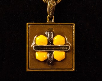 Square brass pendant with 4 re-purposed yellow pills and metal details