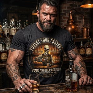 May include: A man wearing a dark gray t-shirt with the text "FORGET YOUR PRAYERS POUR ANOTHER BOURBON" and a skull graphic. He is holding a glass of amber liquid, with a bottle of "OLD BONES" bourbon on the bar. The background includes bottles of liquor.
