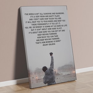 Puede incluir: Impresión en lienzo con una cita de Rocky Balboa y una imagen en escala de grises de una persona con el puño en alto. La cita en blanco sobre un fondo gris, con una vista de la ciudad.