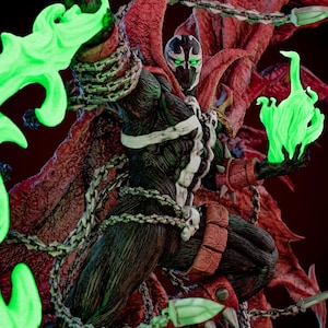 Könnte beinhalten: Detaillierte Actionfigur von Spawn, einer Comicfigur, in einer dynamischen Pose. Die Figur ist überwiegend schwarz mit weißen Akzenten, einem roten Umhang und Ketten. Sie verfügt über leuchtende grüne Energieeffekte und ist vor einem dunkelroten Hintergrund platziert.