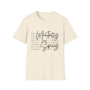 May include: Cream-colored t-shirt with the words "Mentally Spicy" in a handwritten font. The shirt also lists descriptive words such as "Edgy," "Sassy," and "Independent."
