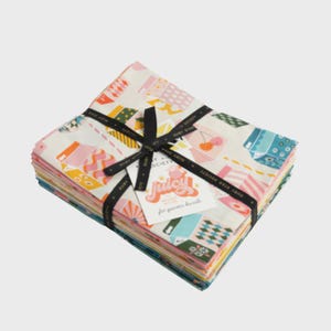 May include: A stack of folded fabric squares tied with a black ribbon featuring the text Ruby Star Society. The fabric has a cream background with a colourful pattern of juice cartons, cherries, and geometric shapes. A tag reads Juicy by Melody Miller.