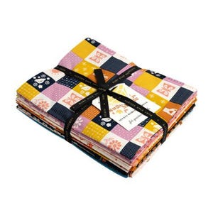 Könnte beinhalten: Ein Stapel gefalteter Stoffquadrate, zusammengebunden mit einem schwarzen Band, das den Text Ruby Star Society trägt. Der Stoff zeigt ein Patchwork-Muster aus gelben, rosa und marineblauen Quadraten mit Motiven von Schmetterlingen, Blumen und Vögeln.
