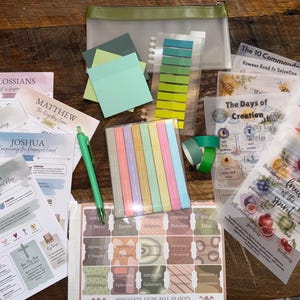 May include: A collection of religious study materials including printed sheets with titles like Colossians, Matthew, Job, Joshua, and Genesis, a green pen, a set of pastel sticky notes, a green zipper pouch, and translucent sheets with illustrations.