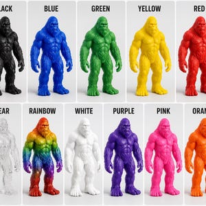 May include: A collection of Bigfoot figurines in various colors, including black, blue, green, yellow, red, clear, rainbow, white, purple, pink, and orange. Each figurine is labeled with its corresponding color.
