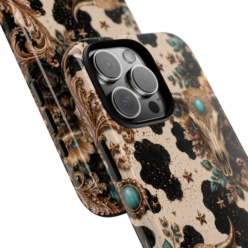 a phone case with a black and white cow pattern, along with gold and turquoise accents.
