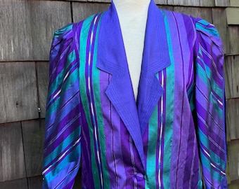 Chaqueta tipo blazer de seda estilo glamuroso de los años 80, con rayas verdes y moradas, talla M/L. Mangas con aberturas laterales y bolsillos.