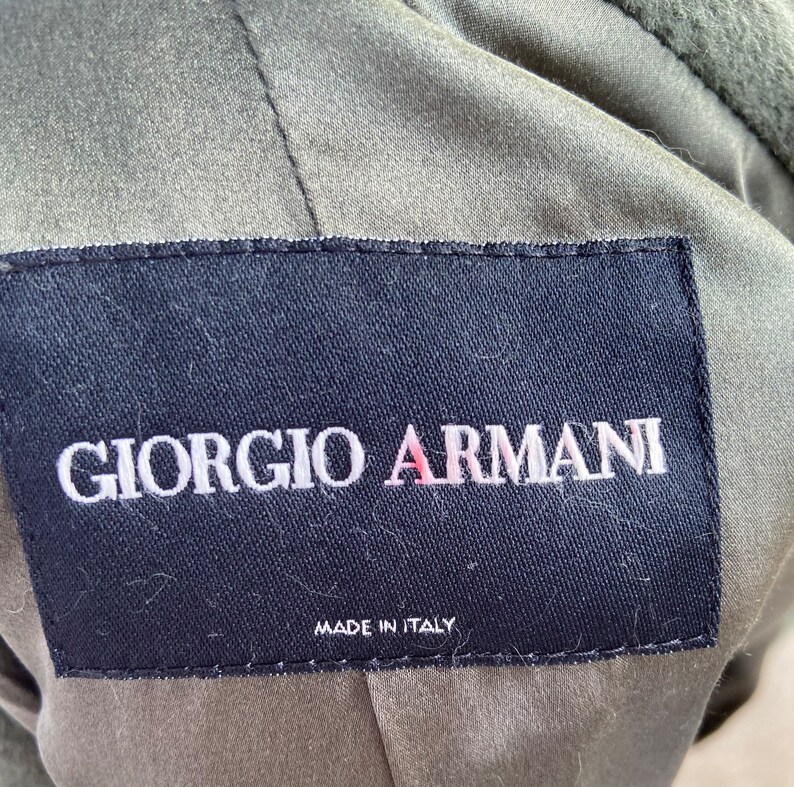 May include: A black label with white stitching and the text "Giorgio Armani" in white lettering. The label also has the text "Made in Italy" in white lettering.