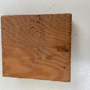 May include: A piece of unfinished, light brown wood with a natural wood grain pattern.