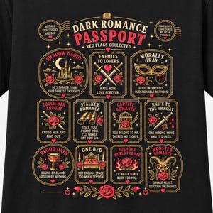 May include: A black t-shirt featuring a graphic titled Dark Romance Passport with Red Flags Collected. It displays twelve rectangular and circular frames containing illustrations of roses, swords, masks, cages, and hearts with text captions like Shadow Daddy, Enemies to Lovers, and Morally Gray.
