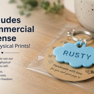 May include: A light blue cloud-shaped pet tag with the name RUSTY embossed on the front, attached to a silver metal keyring. The tag is mounted on a circular brown card featuring paw print and heart icons, enclosed in a clear plastic sleeve.