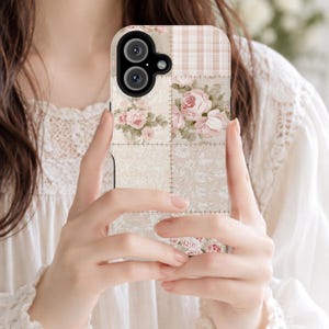 Puede incluir: Una funda para smartphone con un diseño de patchwork en tonos beige y crema suaves. El patrón incluye secciones de rosas de color rosa claro, una cuadrícula sutil y texturas de encaje floral, separadas por líneas de costura visibles.