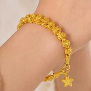 Peut inclure: Un bracelet en or composé d'une chaîne continue de petites perles texturées en forme de fleurs. Le bracelet présente un fermoir à crochet sécurisé et une breloque en forme d'étoile à cinq branches avec une finition mate et granuleuse.