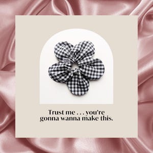 Puede incluir: Una goma para el pelo a cuadros blancos y negros con un diseño floral. La goma tiene una pequeña etiqueta blanca con el texto "Studio Aether". El texto "Trust me... you're gonna wanna make this" está debajo.