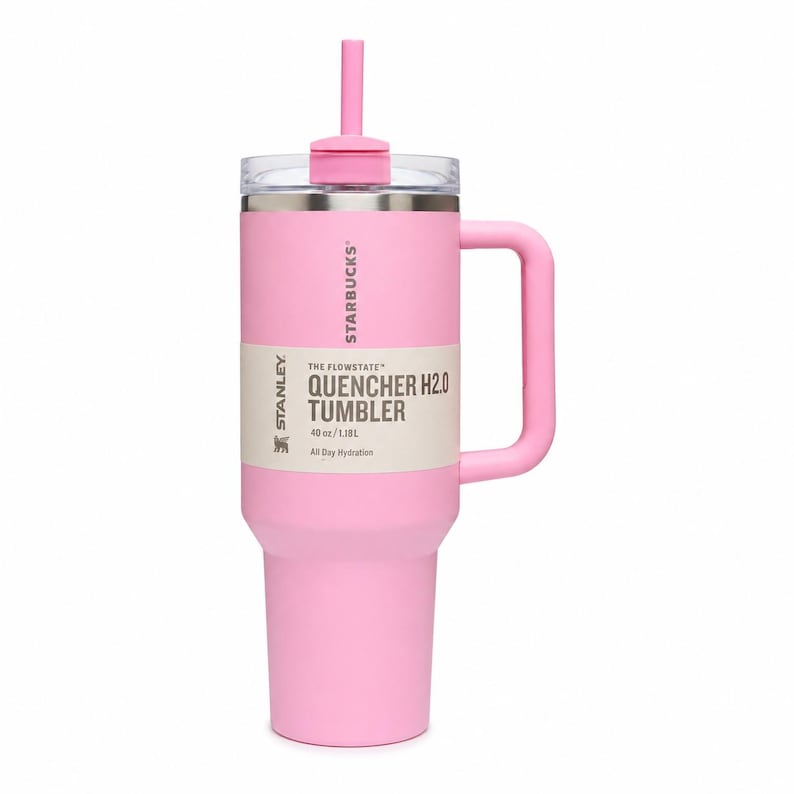 May include: A light pink Stanley Starbucks Quencher H2.0 tumbler with a 40 oz capacity. The cup features a matching pink handle, a clear lid, and a pink straw. A beige product label is wrapped around the center with the text Starbucks and Stanley.