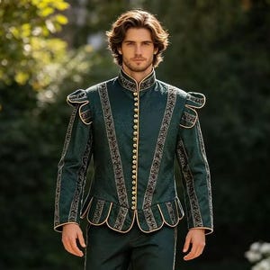 Könnte beinhalten: Eine dunkelgrüne Doublet-Jacke mit Stehkragen, langen Ärmeln mit strukturierten Schulterkappen und einem Schößchensaum. Das Kleidungsstück ist mit goldfarbenen Knöpfen in der Mitte und aufwendigen schwarz-goldenen Stickereien an den Nähten verziert.