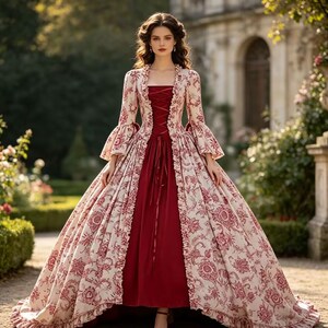 May include: A floor-length gown featuring a solid deep red skirt and a cream-colored overcoat with a red floral pattern. The overcoat has long bell sleeves, ruffled edges, and a lace-up bodice detail that reveals the red fabric underneath.