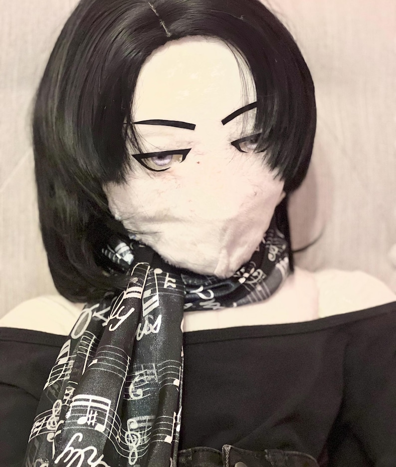 May include: A black off-the-shoulder top with a black and white musical note scarf. The scarf is draped around the neck. The image also shows a black wig and a face mask.