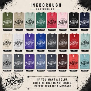 May include: A color chart displaying twenty-eight t-shirts in various shades, each featuring a circular Inkborough Clothing Co. logo with a city skyline graphic. The text reads Inkborough Clothing Co. and includes color names below each shirt.