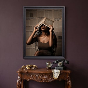 May include: A framed wall art print featuring a person with long dark braids holding an open book over their face. The background consists of vintage newspaper columns with text including History and Truth, Voices from the Past, and Knowledge as Power.