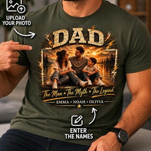 May include: Olive green t-shirt with a graphic featuring the word "DAD" in large, bold letters above a family portrait. The text "The Man * The Myth * The Legend" and names are below the image. Includes prompts to upload a photo and enter names.