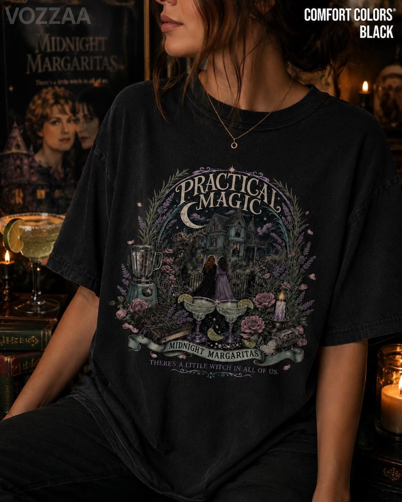 May include: A black t-shirt featuring a graphic print with the text Practical Magic, Midnight Margaritas, and There's a little witch in all of us. The design includes a house, two figures, a blender, margaritas, flowers, and a crescent moon.