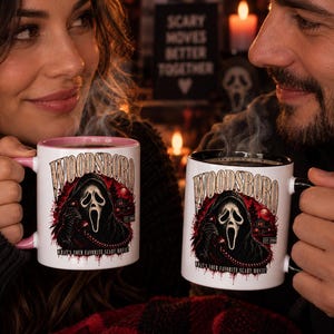 Puede incluir: Dos tazas de cerámica blanca con un gráfico de una figura enmascarada sosteniendo un teléfono, el texto WOODSBORO y la frase WHAT'S YOUR FAVORITE SCARY MOVIE? Una taza tiene asa e interior rosa, la otra tiene asa e interior negro.