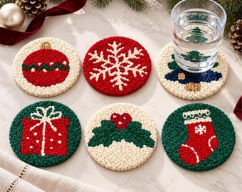 Puede incluir: Un juego de seis posavasos circulares y texturizados con diseños navideños que incluyen una bola roja, un copo de nieve blanco sobre rojo, un árbol de Navidad, un regalo rojo, hojas de acebo verdes con una baya roja y un calcetín rojo.