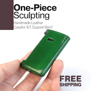 Könnte beinhalten: Eine handgefertigte, grüne Lederhülle für ein S.T. Dupont Slim7 Feuerzeug. Die Hülle ist ein einteiliges Sculpting-Design. Der Text "One-Piece Sculpting" und "Handmade Leather Case for S.T. Dupont Slim7" sind sichtbar. Die Worte "FREE SHIPPING" sind ebenfalls sichtbar.