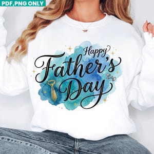 May include: A white long-sleeve sweatshirt featuring a blue and teal watercolour splash graphic. The text reads Happy Father's Day in black script. The design includes a gold necktie illustration, silver cufflinks, and small gold star accents.