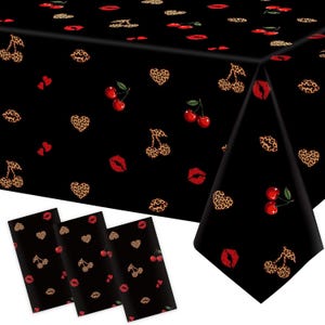 May include: A black tablecloth and three matching napkins featuring a repeating pattern of red cherries, red lips, leopard print hearts, and leopard print cherries. The design is consistent across all items, showcasing a bold, high-contrast graphic print.