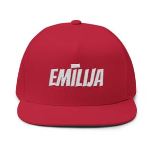 Può includere: Cappellino da baseball rosso con visiera piatta, con il nome "EMILIJA" ricamato in bianco a lettere maiuscole. Il cappellino ha una vestibilità strutturata e una corona rotonda.