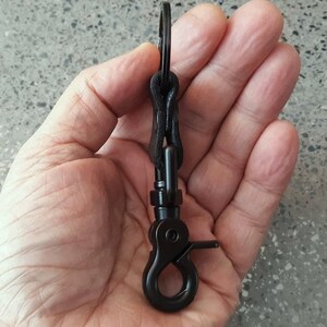 May include: Black metal key chain with a swivel hook and a spring-loaded clip.