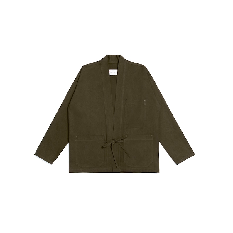 Puede incluir: Una chaqueta de color verde oliva abierta por delante con mangas largas, escote en V y cierre de lazo en la cintura. La prenda cuenta con dos grandes bolsillos de parche en la parte delantera y una etiqueta blanca con texto negro en el cuello.