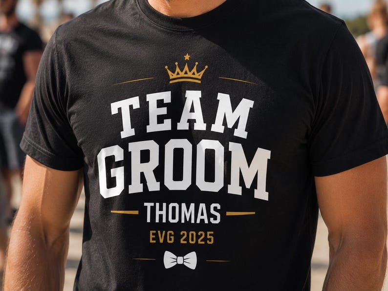 May include: A black short-sleeve t-shirt featuring a gold crown graphic above the white text "TEAM GROOM" and "THOMAS" in a bold font. Below the name, the text "EVG 2025" appears in gold, followed by a small white bow tie graphic.