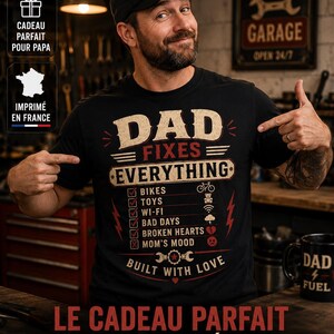 May include: A black t-shirt featuring a graphic design with the text DAD FIXES EVERYTHING and a checklist of items including bikes, toys, wi-fi, bad days, and broken hearts, with the phrase BUILT WITH LOVE at the bottom and a wrench icon.