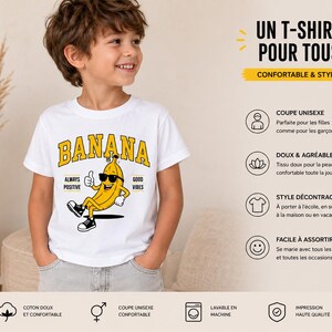 K&ouml;nnte beinhalten: Ein wei&szlig;es T-Shirt mit kurzen &Auml;rmeln und einer Grafik einer gelben Bananenfigur mit schwarzer Sonnenbrille und Turnschuhen, die den Daumen hochh&auml;lt. Der Text BANANA steht in Gelb dar&uuml;ber, erg&auml;nzt durch ALWAYS POSITIVE und GOOD VIBES.