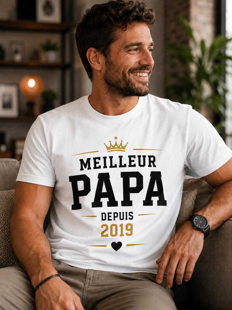 May include: A white short-sleeved t-shirt featuring the text MEILLEUR PAPA DEPUIS 2019 in black and gold lettering. The design includes a gold crown icon above the text, a small black heart icon below the year, and horizontal gold lines.